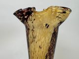 a glass vase that has a brown and black design on it