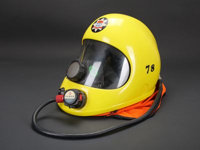 casque de pompier jaune sur fond noir, avec un cordon noir