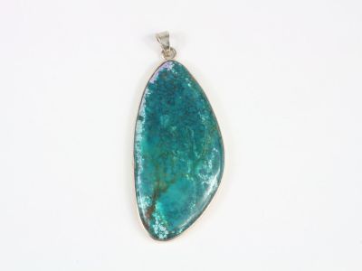a close up of a blue stone pendant on a white surface