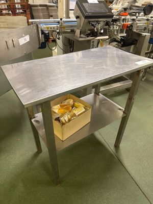 une table sur laquelle se trouve un panier rempli de nourriture, au milieu d'une cuisine