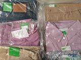 several pairs of men ' s shirts in plastic bags on a table