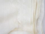 cream linen with white lace trims on top of a bed