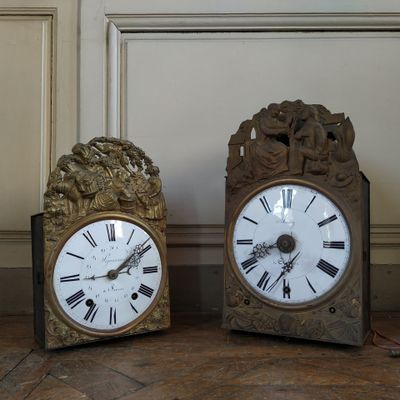 two clocks that are sitting next to each other on the floor