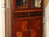 a wooden cabinet with a glass door on top of it