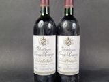 two bottles of red wine sitting next to each other on a table