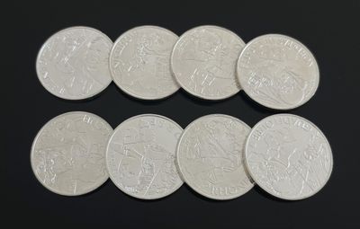 six types différents de pièces d'argent sur une surface noire