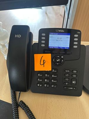 a telephone that is sitting on a desk next to a computer