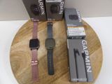 deux montres posées sur un plateau en bois à côté d'une boîte Garmin