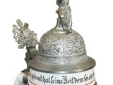 a beer mug that has a statue on top of it