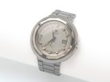 une montre argentée posée sur une surface blanche, sur fond blanc
