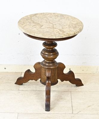 une photo d'une petite table avec un plateau en marbre posée sur un sol carrelé