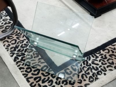 une table en verre avec un tapis à motif léopard posé au sol