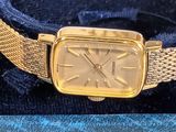 an image of a gold watch sitting on top of a blue box