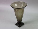 a glass vase sitting on a stand on a table