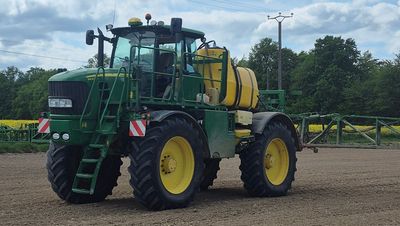 a tractor with a sprayer on the back of it in a field