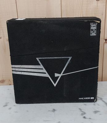 une boîte noire sur laquelle est dessiné un triangle, posée sur une table