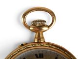 a gold pocket watch with roman numerals on the face