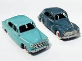 deux voitures jouets assises l'une à côté de l'autre sur une surface blanche