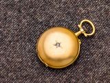 une montre de poche en or sertie d'un diamant