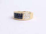 un gros plan d'une bague en or jaune sertie de diamants noirs et blancs