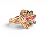 an image of a gold ring with multi colored stones on it