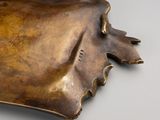 a bronze sculpture of a cow ' s head on a table
