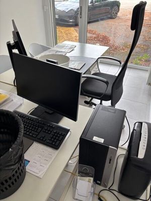 un bureau sur lequel se trouvent un ordinateur, un clavier, une souris et d'autres objets