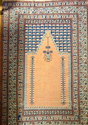 un tapis oriental aux motifs bleus et blancs posé sur un parquet