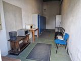 une pièce équipée d'une table, d'une chaise, d'un micro-ondes et d'autres objets