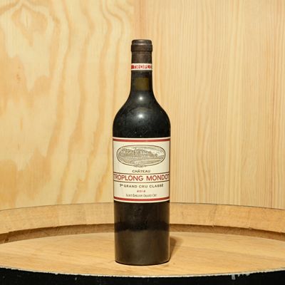 a bottle of wine sitting on top of a barrel