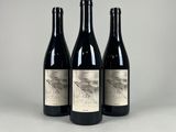 three bottles of wine sitting on top of a table