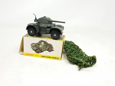 un véhicule militaire miniature avec un sapin de Noël devant