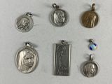 several different types of religious charms are displayed on a white surface