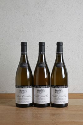 trois bouteilles de vin posées sur une table en bois