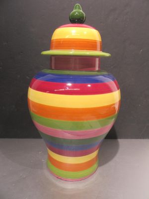 un vase multicolore muni d'un couvercle, posé sur une table