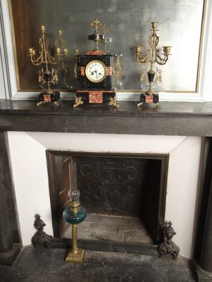 a mantle with a clock on top of it in a room