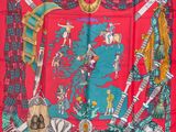 foulard en soie rouge orné d'une illustration représentant des vêtements et des accessoires pour femmes