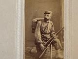 an old photo of a man holding a rifle