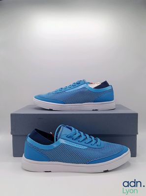 une paire de baskets bleues posée sur une boîte