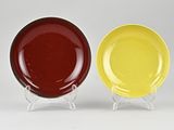 two yellow and red plates sitting side by side on a white surface