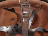 a close up of a leather helmet with a metal buckle