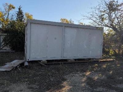 a white container sitting in the middle of a dirt field