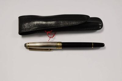 un stylo noir et un étui noir posés sur une surface blanche