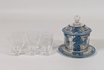 un bocal bleu et blanc et des verres posés sur une table blanche
