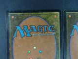 two decks of magic the gathering are shown on a black surface