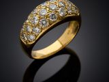 a gold and diamond ring on a black surface
