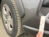 a hand that is holding a ruler next to a car