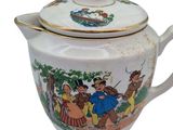 a tea pot with a lid that has a picture of people on it
