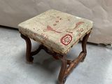 un petit tabouret en bois avec une assise rembourrée à motifs floraux