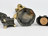two pieces of metal and a cork on a white surface